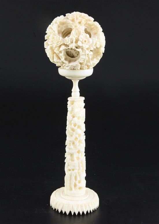 A Chinese ivory concentric puzzle ball and stand, early 20th century, ball 6.7cm, total height 23cm